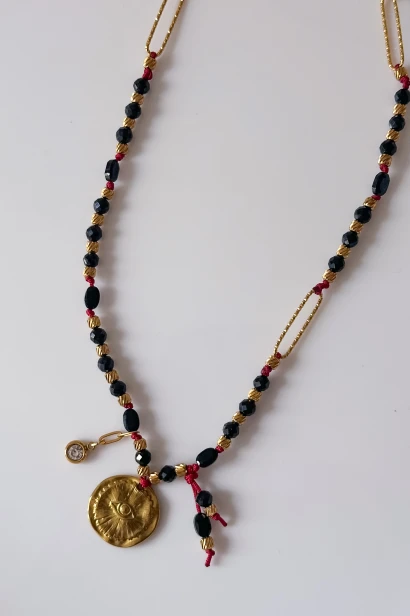 Złocony medalion z okiem i cyrkonia na naszyjniku z czarnego turmalinu, detal biżuterii handmade Lulobelia, projekt autorski Polska