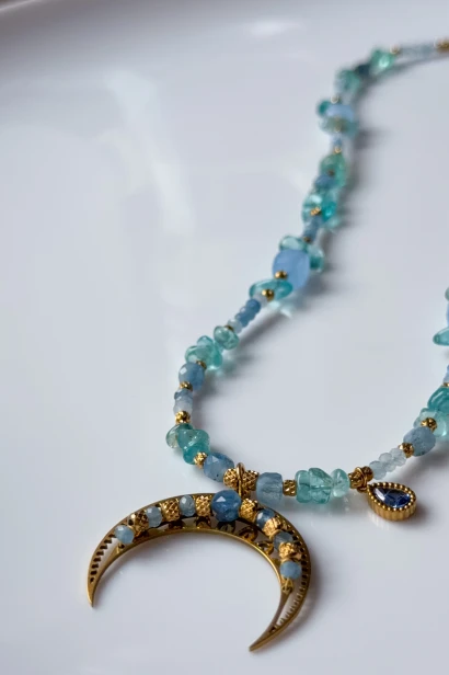 Detal naszyjnika Lulobelia lunula, błękitne kamienie i złoty półksiężyc, biżuteria boho morska handmade Polska