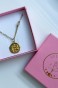 Naszyjnik dla Wagi z kamieniem księżycowym i medalionem z symbolem znaku zodiaku, ułożony w różowym pudełku Lulobelia.